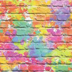 colorful paint splattered on a brick wall