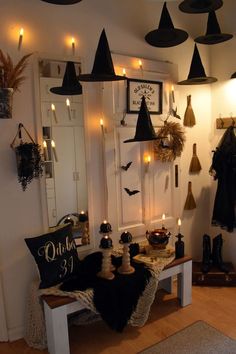 a room decorated for halloween with candles and witches hats hanging from the ceiling, while other decorations are on the wall