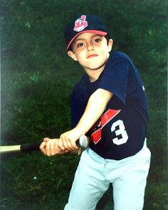 a young boy is holding a baseball bat