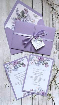 the wedding stationery is purple and has flowers on it