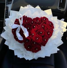 a heart - shaped rose bouquet in the center of a car