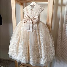 This exquisite Rose Gold Flower Girl dress is sure to make your little one shine on any occasion. The dress is adorned with intricate beading and delicate lace trims, complemented by charming cap sleeves. The luxurious embroidery and prominent bow at the back add a touch of elegance to this already stunning dress. Perfect for any and every special occasion, this dress is the epitome of style and sophistication. Fabric Type: Tulle Suggested Age Bust Waist Hips Hollow to Floor Inch cm Inch cm Inch Elegant Lace First Communion Dress With Floral Applique, Elegant Princess Dress With Floral Applique In Lace, Elegant Lace Princess Dress With Floral Applique, Short Sleeve Lace Princess Dress For Wedding, Elegant Princess Dress With Floral Applique For First Communion, Elegant First Communion Princess Dress With Floral Applique, Elegant Lace First Communion Dress For Pageant, Elegant Lace First Communion Dress, Elegant First Communion Dress With Bow