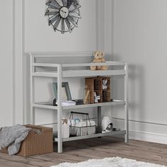 a white shelf with books and toys on it next to a rug in a room