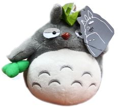 a gray and white stuffed animal with green leaves on it's head