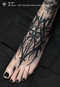 a person's foot with black ink on it and an intricate design in the middle