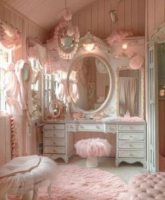 a pink bedroom with white furniture and lots of decorations on the walls, including a dressing table