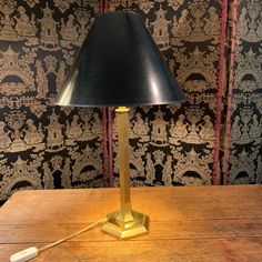 a lamp that is sitting on top of a wooden table next to a wallpaper