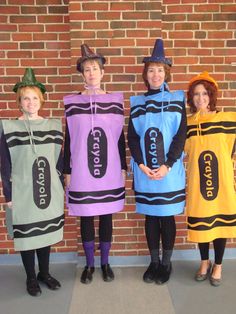 three children in costumes standing next to a brick wall