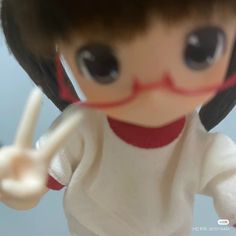 a close up of a doll holding a toothbrush