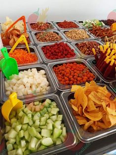 several trays filled with different types of food and chips on top of each other