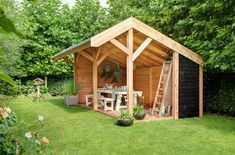 a small wooden shed sitting on top of a lush green field