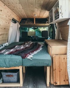 the interior of an rv with wood paneling and bedding in place for storage