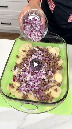 a person in an apron is mixing food into a bowl on top of a green tray