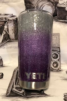 a purple and silver glittered yeti tumbler sitting on top of a table