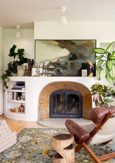 a living room filled with furniture and a fire place next to a painting on the wall