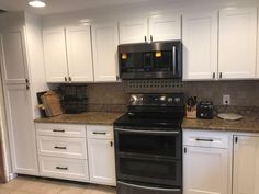 a black stove top oven sitting inside of a kitchen next to white cabinets and drawers