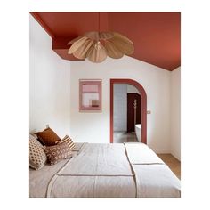 a large bed sitting under a ceiling fan next to a wall mounted light in a bedroom