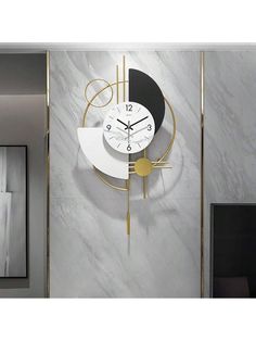 a clock that is on the wall next to a mirror and door with gold trim