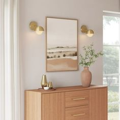 a wooden cabinet with two vases and a painting on the wall