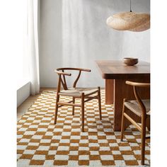 two wooden chairs sitting on top of a checkered rug