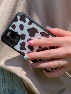 a woman's hand holding an iphone case with brown and white spots on it