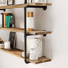 three wooden shelves with black pipe brackets and books on them, along with other decorative items