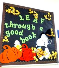 a sign that says leaf through a good book with peanuts and pumpkins on it