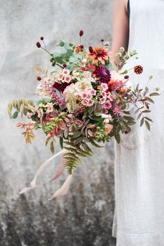 a woman holding a bouquet of flowers in her hand