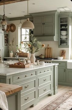 a kitchen filled with lots of green cabinets and counter top space next to a window