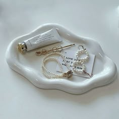 a white tray topped with pearls and jewelry