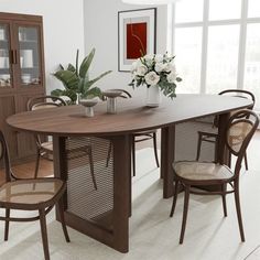 a dining room table with chairs and a vase filled with flowers on top of it