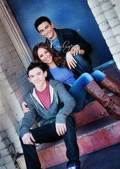 three people posing for a photo on some steps