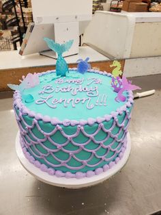 a blue and purple cake sitting on top of a table