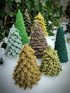 crocheted christmas trees sitting in the snow