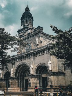 an old building with a clock tower on it's side and stairs leading up to the entrance