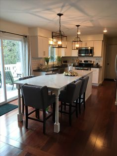 a kitchen with a table and chairs in front of a sliding glass door that leads to an outside deck