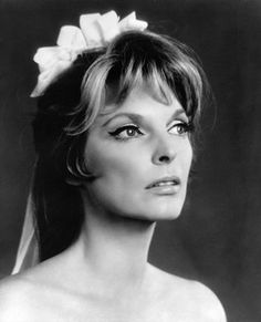 black and white photo of a woman wearing a wedding dress with a bow in her hair