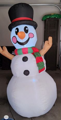 a large inflatable snowman with a hat and scarf on it's head