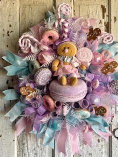 a teddy bear sitting on top of a cake surrounded by candy and candies in pastel colors