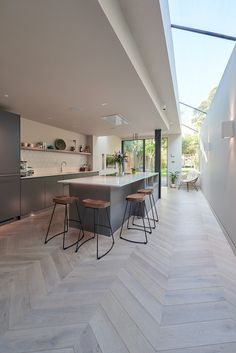 an open kitchen and dining area with wood flooring