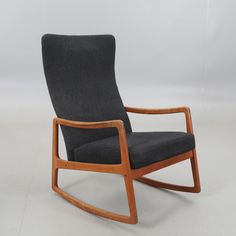 a rocking chair with black upholstered fabric and wooden frame