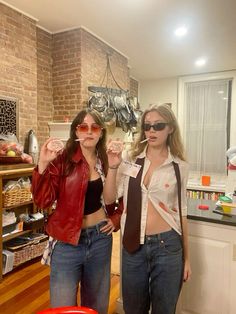 two women standing next to each other in a room with brick walls and wooden floors