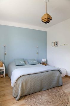 a bed sitting in a bedroom next to a wall with blue paint on the walls