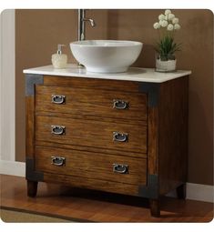 a bathroom vanity with a bowl sink and wooden drawers