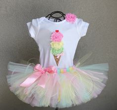 a white shirt with an ice cream cone on the front and pink bows at the bottom