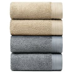 three towels stacked on top of each other in white and beige colors, with one folded up