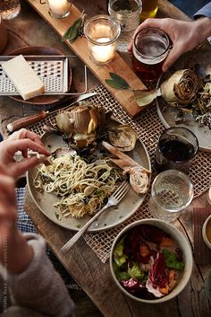 people are sitting at a table with food and drinks