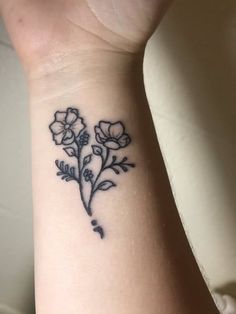 a black and white flower tattoo on the wrist