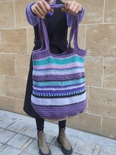 a woman holding onto a crocheted purse