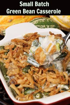 small batch green bean casserole in a red and white dish with a spoon